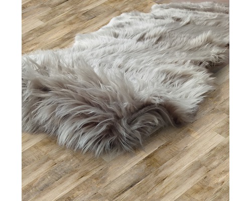 Grå matta med lång lugg på trägolv