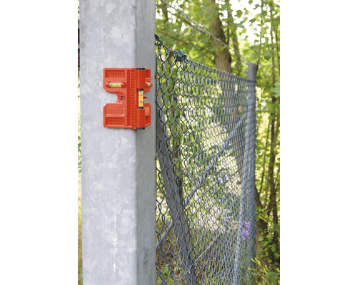 Orange stängselvattenpass på en stängselstolpe för justering under stängselkonstruktion