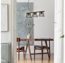 Matsal med träbord, stolar och taklampa med tre lampskärmar