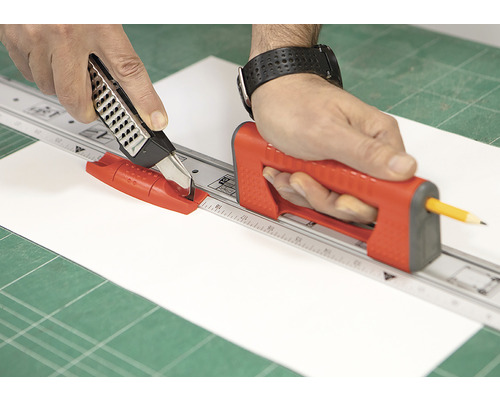 Person skär papper med rullkniv och skärlinjal