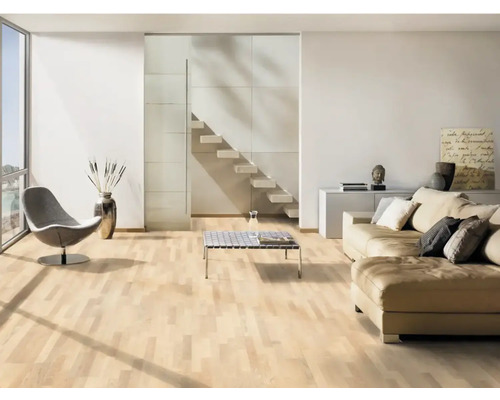 Ljust vardagsrum med parkettgolv, soffa, fåtölj och trappa