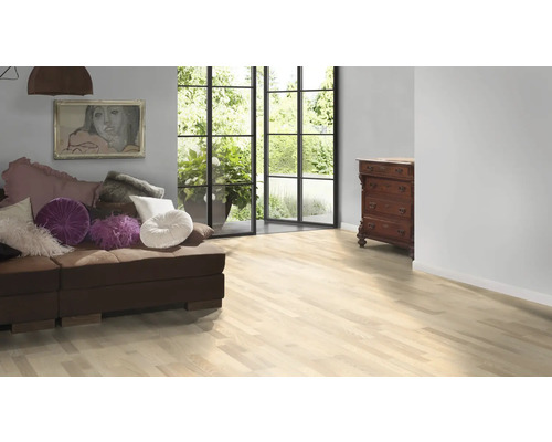 Ljust rum med trägolv, soffa och byrå