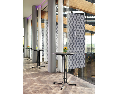 Ståbord i ett ljust rum med stora fönster och pelare