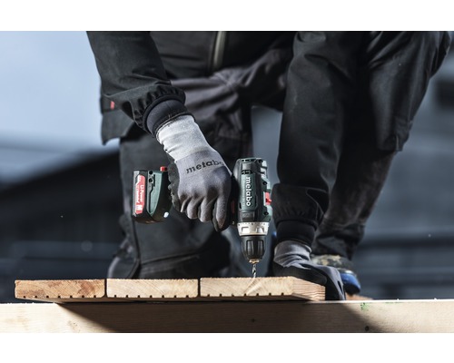 En person borrar ett träbräde med en Metabo sladdlös skruvdragare.