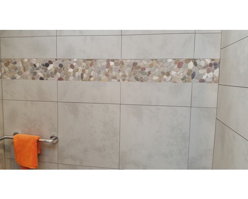 Väggplattor med grusstenkant i ett badrum.