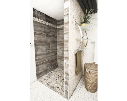 Badrum med dusch, kakel och dekorativa föremål för en ljus och vänlig atmosfär.