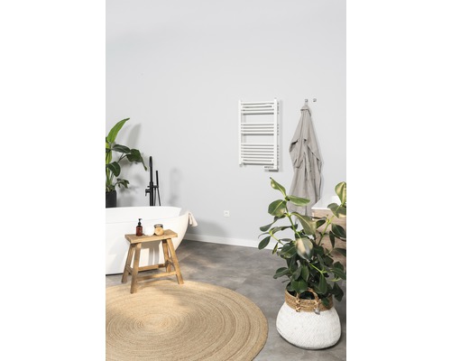 Badrum med badkar, handdukstork och dekorationer