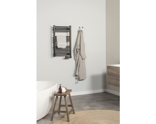 Badrum med handdukstork, handduk, badrock, pall och badkar