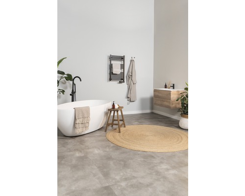 Ljust badrum med fristående badkar, träpall och radiator