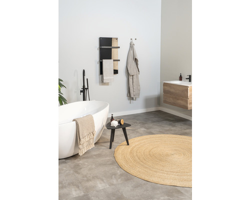 Badrum med fristående badkar, handdukstork, pall och rund matta