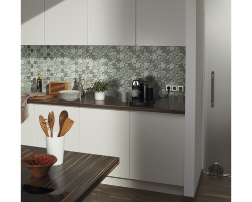 Köksscen med mosaikplattor, köksredskap, kaffebryggare och träbord