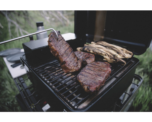 Grill med biffar och majskolvar på grillgallret