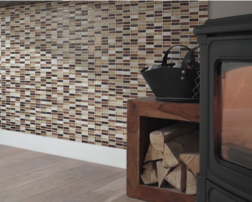 Väggdekoration med mosaikplattor bredvid en vedspis med ved