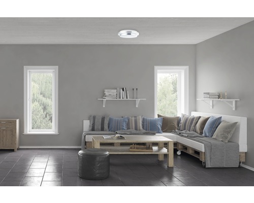 Vardagsrum med soffa av lastpallar, träbord, hyllor och taklampa