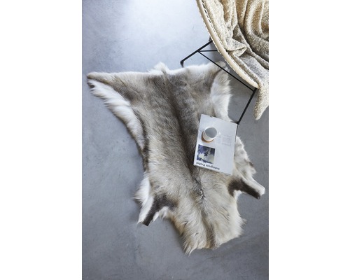 Dekorativ renfäll på golvet bredvid en stol och en tidning.