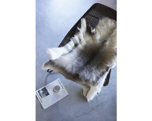 Dekorativt skinn på en stol, med en tidning och en kopp under