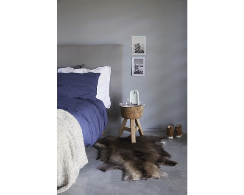 Sovrum med säng, fällmatta och träpall