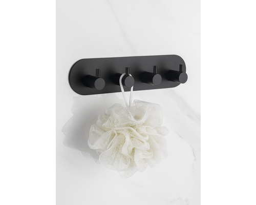 Svart vägghängare med fyra krokar och badsvamp på en marmorvägg