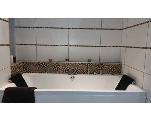 Badrum med badkar, kakelvägg och dekorativa element