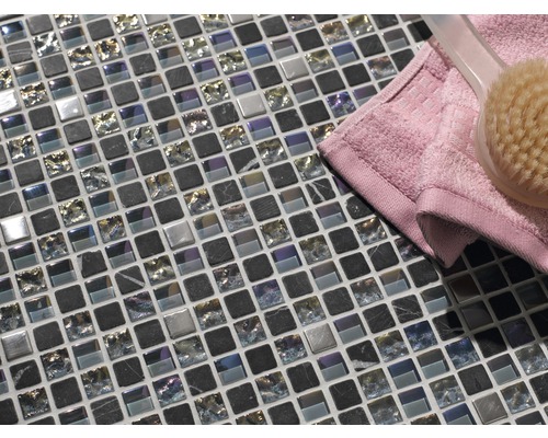 Mosaikplattor av glas och natursten med handduk och borste