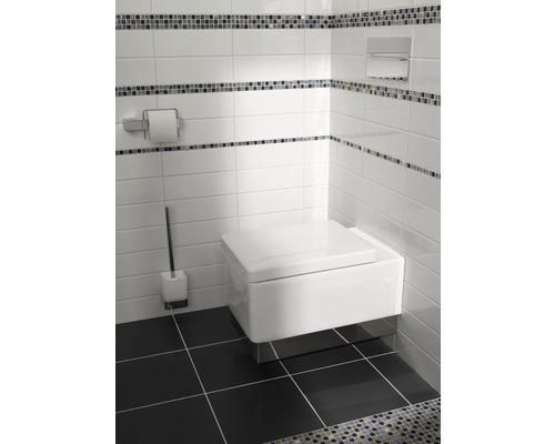 Modernt badrum med vägghängd toalett, toalettborste och pappershållare