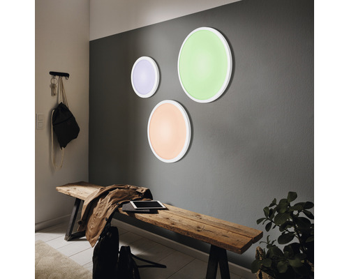 Hall med tre runda vägglampor och en träbänk