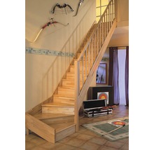 Trätrappa med räcke i ett ljust vardagsrum med dekorationer.