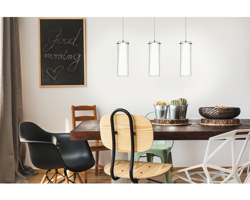 Matbord med stolar, pendellampor och griffeltavla i matsalen