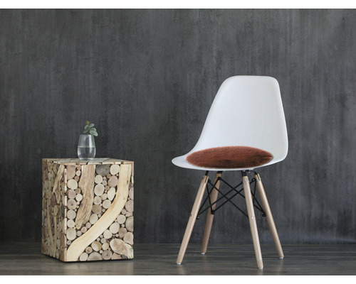 Dekorativt arrangemang med en träpall, en vas och en stol med sittdyna.