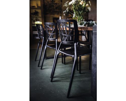 Flera svarta stolar vid ett matbord med modern design.