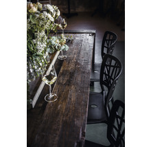 Matbord i trä med blomsterdekorationer, glas och stolar