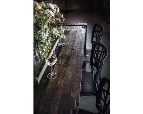 Matbord i trä med blomsterdekorationer, glas och stolar