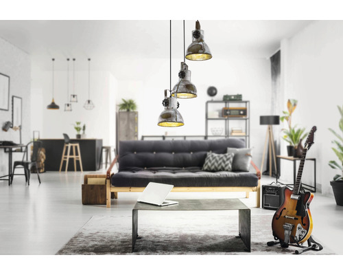 Vardagsrum med en grå soffa, ett bord, en gitarr och en hängande lampa