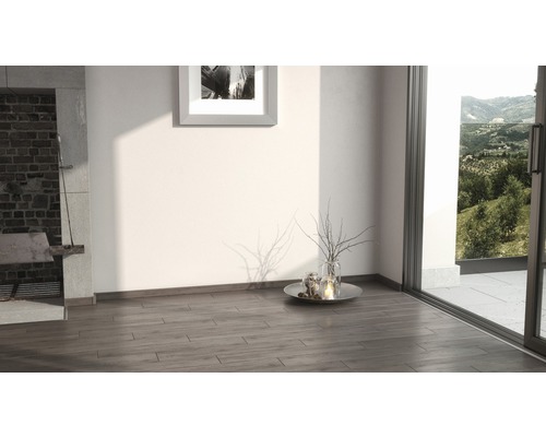 Interiör med trägolv, öppen spis och utsikt över grönområden