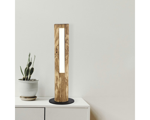 Golvlampa i trä med integrerad belysning på ett bord