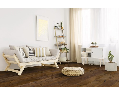 Ljust vardagsrum med trägolv, soffa, hylla och byrå