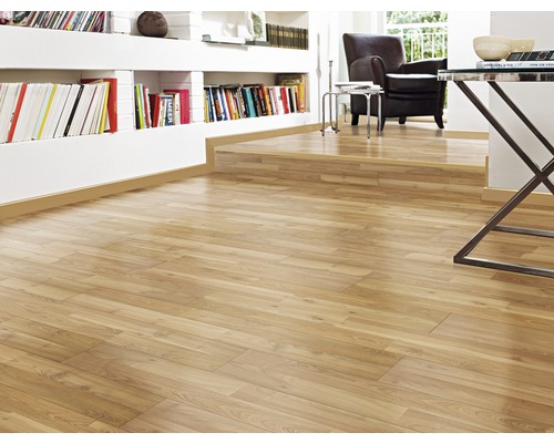 Vardagsrum med ljust laminatgolv, bokhylla och fåtölj