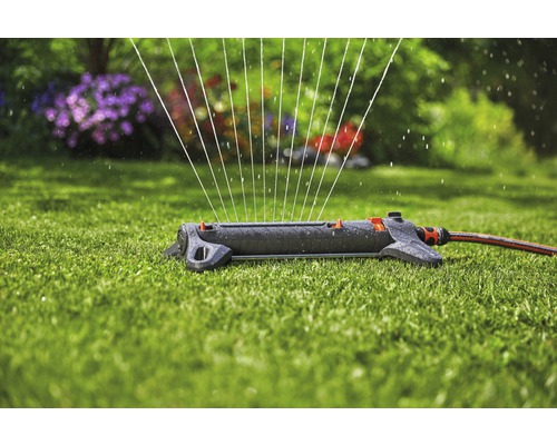 Grässprinkler bevattnar en trädgård