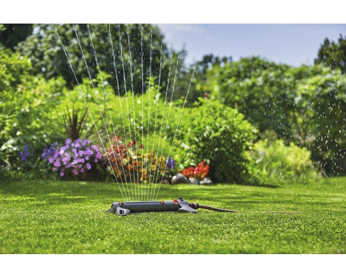 Grässpridare i drift på en grön gräsmatta