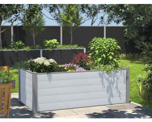 Upphöjd planteringslåda i plast med växter i trädgården