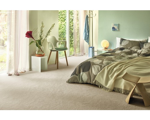 Ljust sovrum med heltäckningsmatta, säng och stol