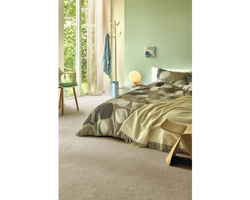 Ljust sovrum med säng, matta och dagsljus