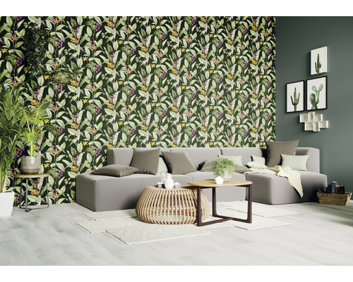 Vardagsrum med blommiga djungeltapeter, soffa och soffbord.