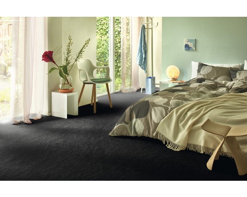 Sovrum med mörk heltäckningsmatta, säng och fönster