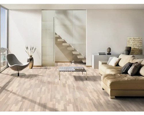 Ljust vardagsrum med parkettgolv, soffa, fåtölj och trappa