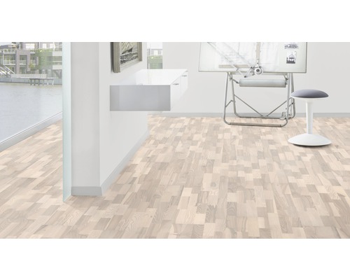 Ljust rum med trägolv i fiskbensmönster, skrivbord och pall