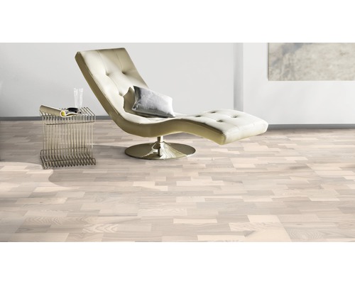 Ljust rum med trägolv, schäslong och sidobord