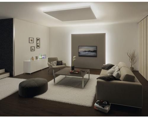 Vardagsrum med taklampa, soffa, fåtölj, bord och TV för en ljus och modern atmosfär.