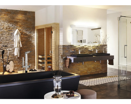 Ljust badrum med badkar, dubbla handfat, bastu och motionscykel