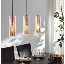 Tre glaspendellampor hänger ovanför ett matbord.